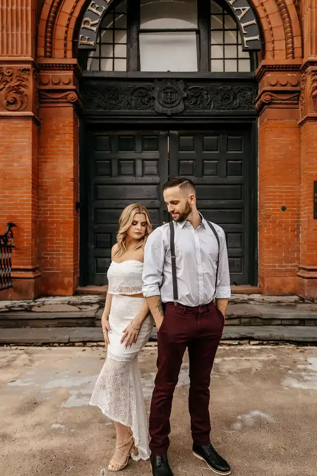 Engaged couple posing together near a historic brick building photographed by a wedding photographer in Georgia.